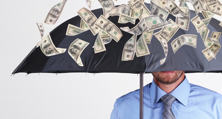 A man standing under an umbrella with money raining down